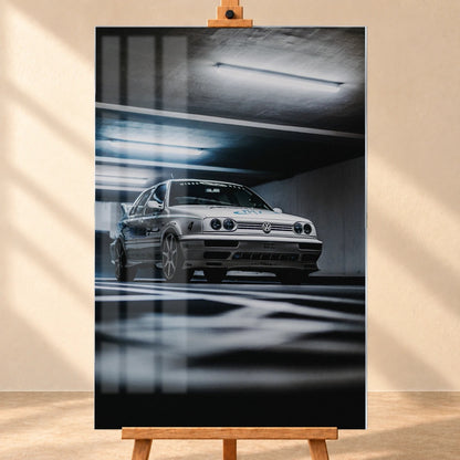 Jesses Jetta fährt frontal durch ein Parkhaus; Bewegungsunschärfe in Boden und Decke verstärkt den Eindruck von Tempo. Motiv „Road Story“ als Acrylglas-Wandbild, frontal auf einer Holzstaffelei.