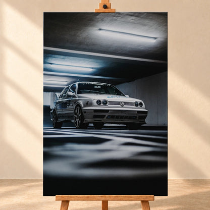 Jesses Jetta fährt frontal durch ein Parkhaus; Bewegungsunschärfe in Boden und Decke verstärkt den Eindruck von Tempo. Motiv „Road Story“ als Leinwand-Wandbild, frontal auf einer Holzstaffelei.