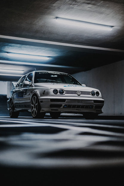 Jesses Jetta fährt frontal durch ein Parkhaus; Bewegungsunschärfe in Boden und Decke verstärkt den Eindruck von Tempo. Originalmotiv „Road Story“ im Hochformat.