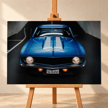Der Camaro Yenko ist frontal und symmetrisch aufgenommen; blaue Haube, weiße Doppelstreifen und runde Scheinwerfer stehen im Mittelpunkt. Motiv „Silver Horizon 2“ als Alu gebürstet-Wandbild, frontal auf einer Holzstaffelei.