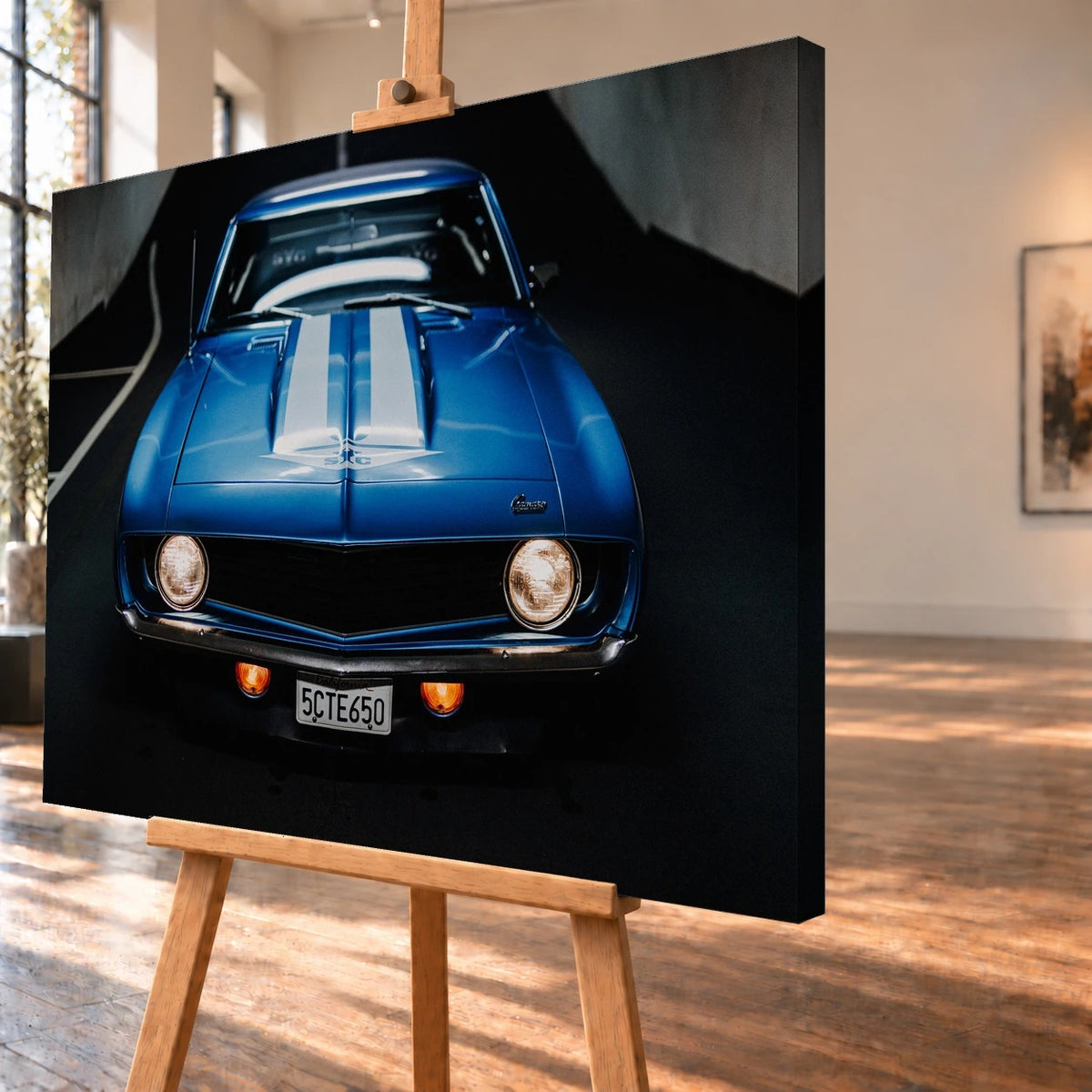Der Camaro Yenko ist frontal und symmetrisch aufgenommen; blaue Haube, weiße Doppelstreifen und runde Scheinwerfer stehen im Mittelpunkt. Motiv „Silver Horizon 2“ als Leinwand-Wandbild, schräg von der Seite auf einer Holzstaffelei.