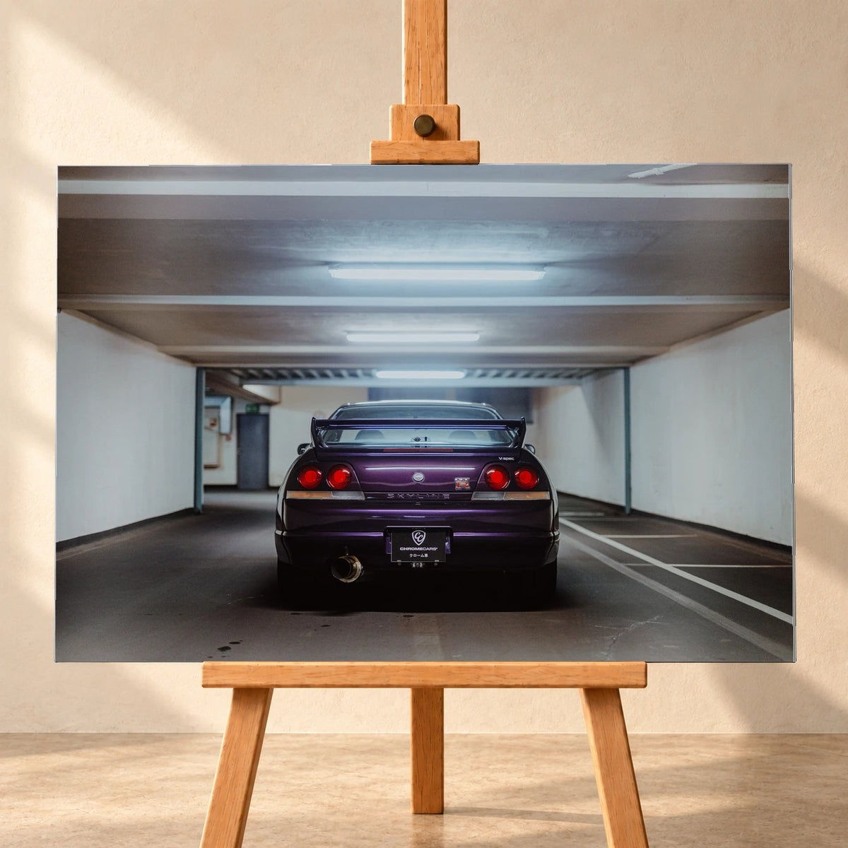 Der Nissan Skyline R33 steht mittig von hinten in einer leeren Parkhausachse; seine vier Rundlichter leuchten vor kühlem Beton. Motiv „Midnight Depth 2“ als Alu gebürstet-Wandbild, frontal auf einer Holzstaffelei.