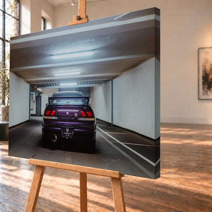 Der Nissan Skyline R33 steht mittig von hinten in einer leeren Parkhausachse; seine vier Rundlichter leuchten vor kühlem Beton. Motiv „Midnight Depth 2“ als Leinwand-Wandbild, schräg von der Seite auf einer Holzstaffelei.