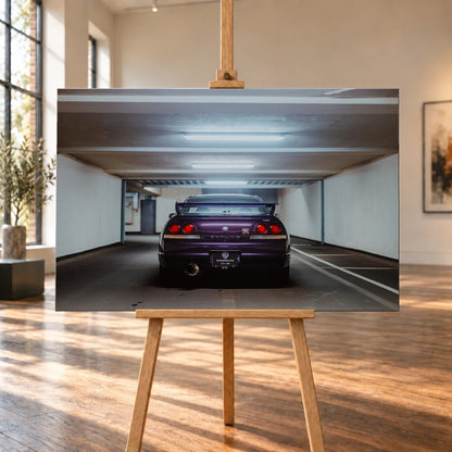 Der Nissan Skyline R33 steht mittig von hinten in einer leeren Parkhausachse; seine vier Rundlichter leuchten vor kühlem Beton. Motiv „Midnight Depth 2“ als Leinwand-Wandbild, auf einer Holzstaffelei in einem hellen Galerieraum.