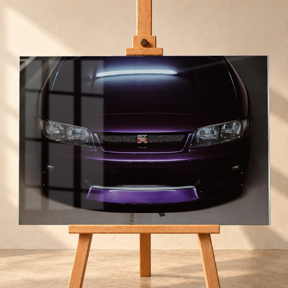 Eine enge Frontalansicht zeigt Grill, GT-R-Emblem und den violetten Frontsplitter des Nissan Skyline R33 vor dunklem Parkhausboden. Motiv „Midnight Rhythm“ als Acrylglas-Wandbild, frontal auf einer Holzstaffelei.