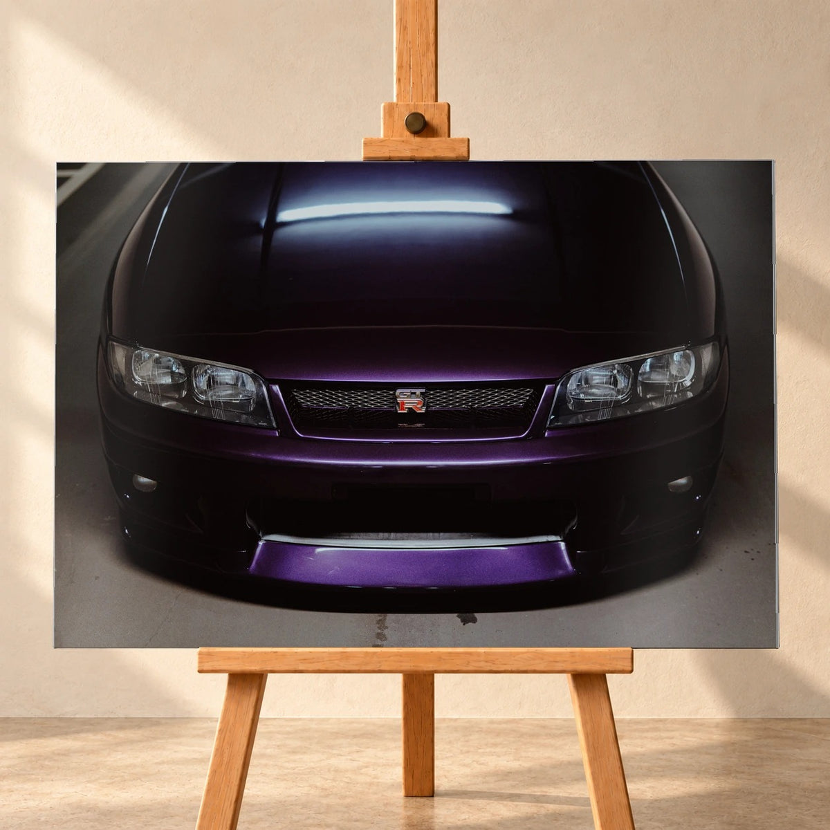 Eine enge Frontalansicht zeigt Grill, GT-R-Emblem und den violetten Frontsplitter des Nissan Skyline R33 vor dunklem Parkhausboden. Motiv „Midnight Rhythm“ als Alu gebürstet-Wandbild, frontal auf einer Holzstaffelei.