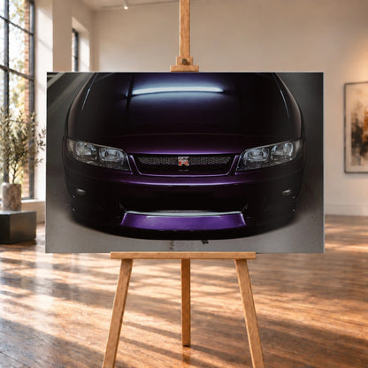 Eine enge Frontalansicht zeigt Grill, GT-R-Emblem und den violetten Frontsplitter des Nissan Skyline R33 vor dunklem Parkhausboden. Motiv „Midnight Rhythm“ als Alu gebürstet-Wandbild, auf einer Holzstaffelei in einem hellen Galerieraum.