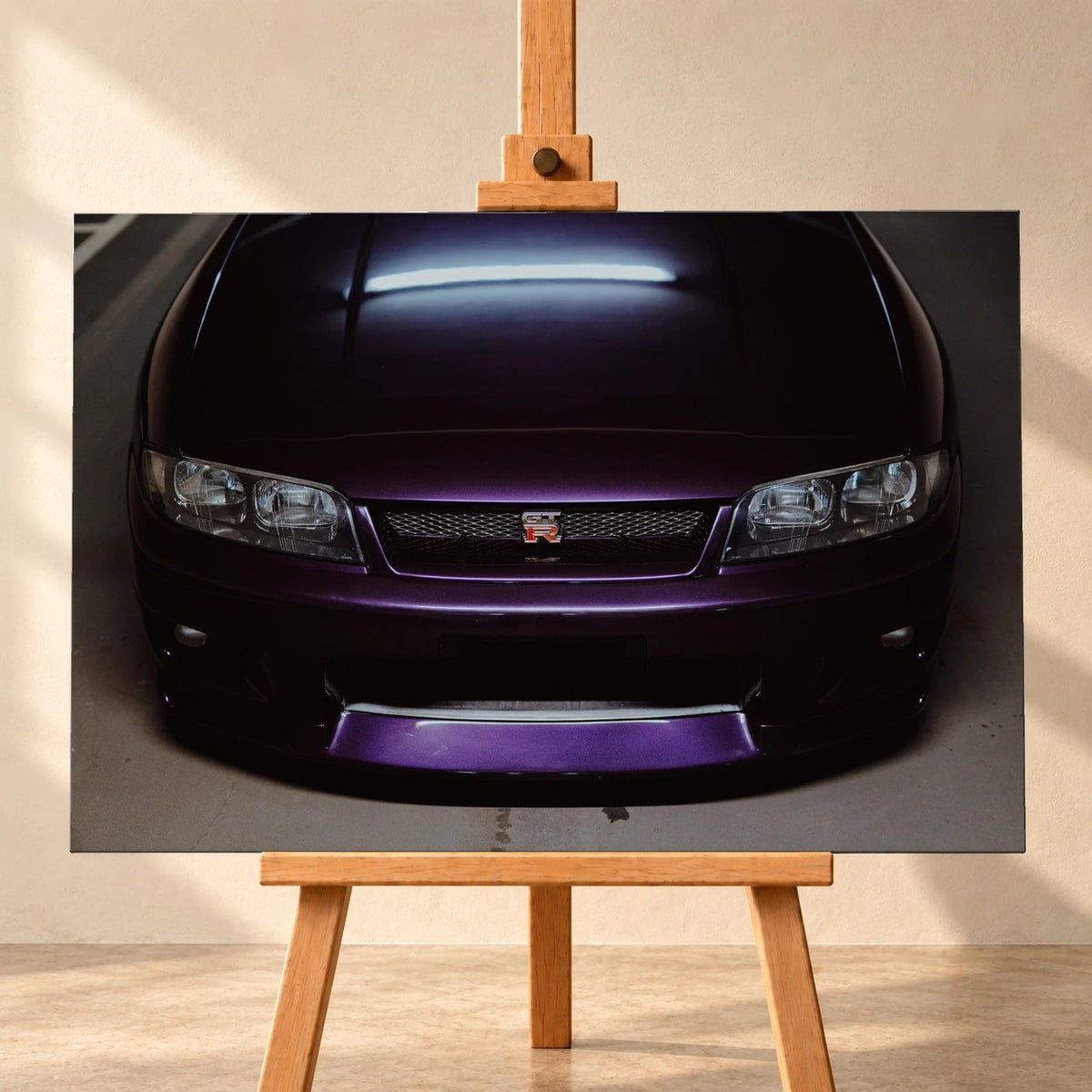 Eine enge Frontalansicht zeigt Grill, GT-R-Emblem und den violetten Frontsplitter des Nissan Skyline R33 vor dunklem Parkhausboden. Motiv „Midnight Rhythm“ als Leinwand-Wandbild, frontal auf einer Holzstaffelei.