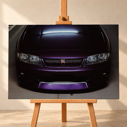 Eine enge Frontalansicht zeigt Grill, GT-R-Emblem und den violetten Frontsplitter des Nissan Skyline R33 vor dunklem Parkhausboden. Motiv „Midnight Rhythm“ als Leinwand-Wandbild, frontal auf einer Holzstaffelei.