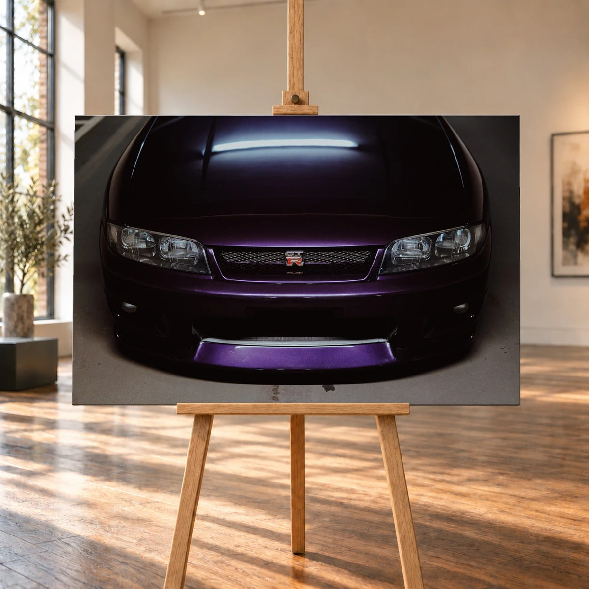Eine enge Frontalansicht zeigt Grill, GT-R-Emblem und den violetten Frontsplitter des Nissan Skyline R33 vor dunklem Parkhausboden. Motiv „Midnight Rhythm“ als Leinwand-Wandbild, auf einer Holzstaffelei in einem hellen Galerieraum.