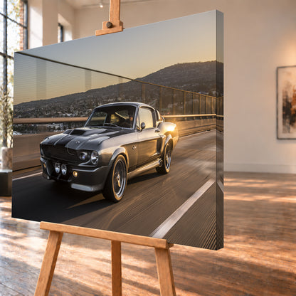 Grauer Eleanor-Sportwagen fährt im Abendlicht über eine Brücke, mit Stadt und Hügeln im Hintergrund; Visualisierung als Leinwand-Wandbild, schräg von der Seite auf einer Holzstaffelei.