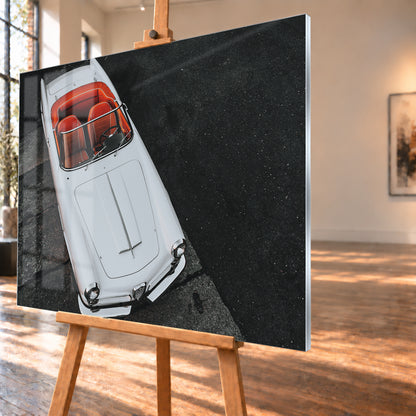 Heller Alfa Romeo 2000 Touring Spider in steiler Aufsicht, diagonal auf dunklem Asphalt; sichtbar sind das offene rot-orange Cockpit, Lenkrad, Windschutzscheibe, lange Motorhaube, runde Frontleuchten und Chromdetails; Visualisierung als Acrylglas-Wandbild, schräg von der Seite auf einer Holzstaffelei.