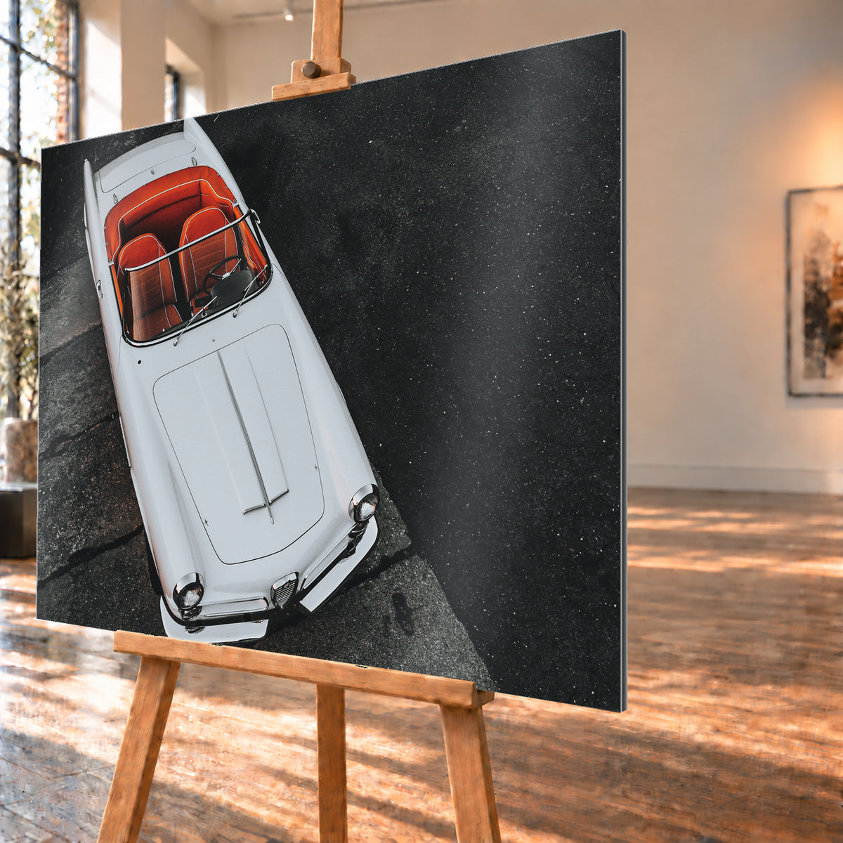 Heller Alfa Romeo 2000 Touring Spider in steiler Aufsicht, diagonal auf dunklem Asphalt; sichtbar sind das offene rot-orange Cockpit, Lenkrad, Windschutzscheibe, lange Motorhaube, runde Frontleuchten und Chromdetails; Visualisierung als Alu gebürstet-Wandbild, schräg von der Seite auf einer Holzstaffelei.