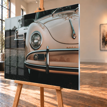 Nahaufnahme der Front eines roséfarbenen Porsche 356 A mit Rundscheinwerfer und Chromstoßfänger rechts; links dahinter steht unscharf ein heller Alfa Romeo 2000 Touring Spider auf dunklem Untergrund unter grauem Himmel; Visualisierung als Acrylglas-Wandbild, schräg von der Seite auf einer Holzstaffelei.