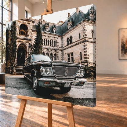 Dunkler Chrysler New Yorker Town & Country in niedriger Front-Dreiviertelansicht vor einem großen historischen Steingebäude mit Rundbögen; warmes Tageslicht spiegelt sich in Chromfront und Lack; Visualisierung als Leinwand-Wandbild, schräg von der Seite auf einer Holzstaffelei.