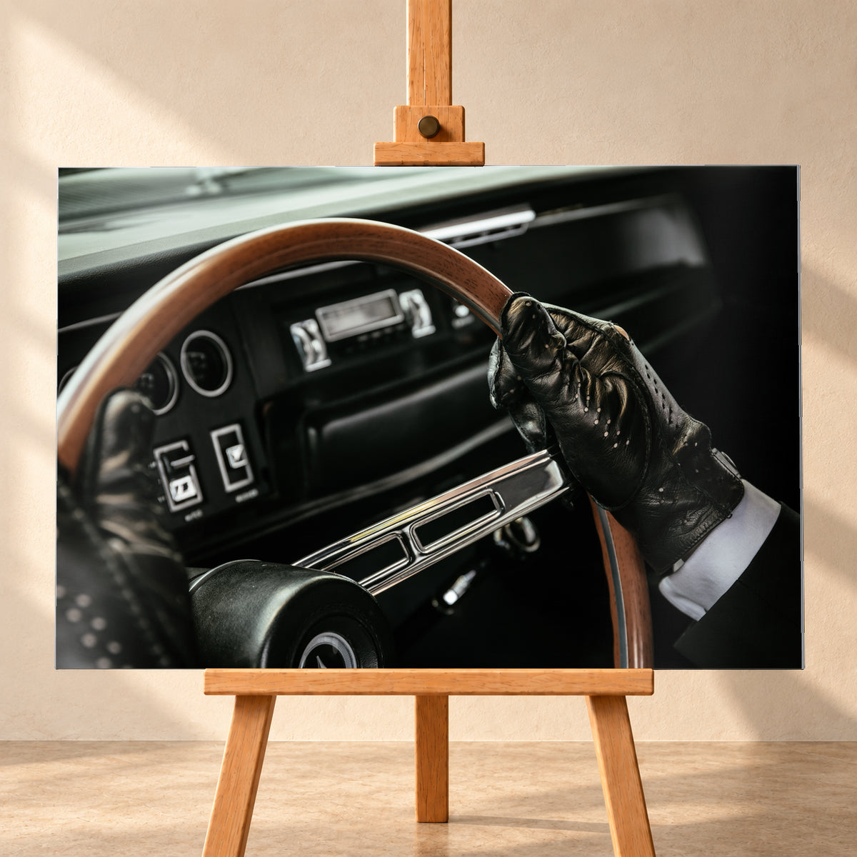 Nahaufnahme eines dunklen Fahrzeugcockpits: Eine Hand in schwarzem, perforiertem Handschuh greift ein braunes, holzfarbenes Lenkrad. Rundinstrumente, Radio und Armaturenbrett liegen unscharf im Hintergrund; seitliches Licht hebt Handschuh, Lenkradkranz und metallisch glänzende Speiche hervor; Visualisierung als Alu gebürstet-Wandbild, frontal auf einer Holzstaffelei.