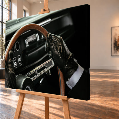 Nahaufnahme eines dunklen Fahrzeugcockpits: Eine Hand in schwarzem, perforiertem Handschuh greift ein braunes, holzfarbenes Lenkrad. Rundinstrumente, Radio und Armaturenbrett liegen unscharf im Hintergrund; seitliches Licht hebt Handschuh, Lenkradkranz und metallisch glänzende Speiche hervor; Visualisierung als Leinwand-Wandbild, schräg von der Seite auf einer Holzstaffelei.