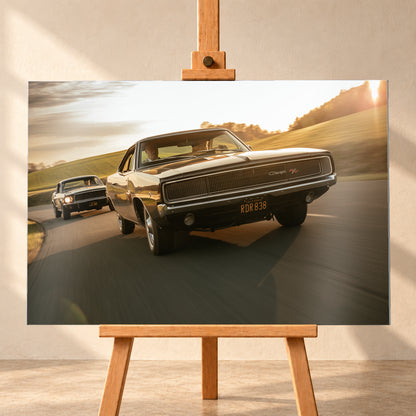 Dunkel erscheinender Dodge Charger R/T aus tiefer Frontperspektive auf einer kurvigen Landstraße; dahinter folgt ein weiteres dunkles Coupé. Goldenes Gegenlicht, grüne Hügel und starke Bewegungsunschärfe prägen die Fahrszene; Visualisierung als Alu gebürstet-Wandbild, frontal auf einer Holzstaffelei.