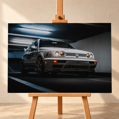 Hellsilberner Volkswagen Jetta mit eingeschalteten Scheinwerfern, grafischen Beklebungen und Nummer 4 in niedriger Front-Dreiviertelansicht auf einer Rampe in einer dunkel und blau beleuchteten Parkgarage; Visualisierung als Leinwand-Wandbild, frontal auf einer Holzstaffelei.