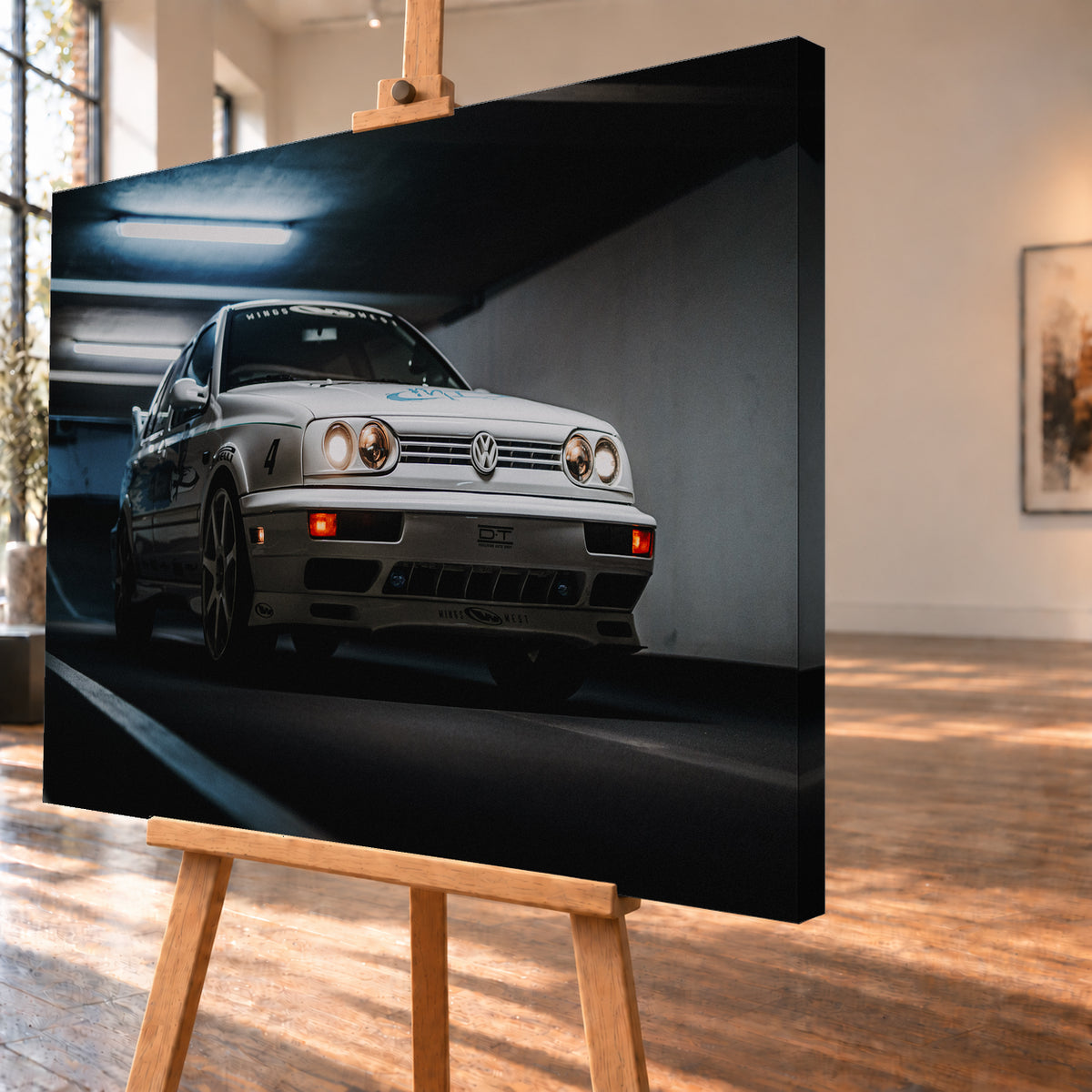 Hellsilberner Volkswagen Jetta mit eingeschalteten Scheinwerfern, grafischen Beklebungen und Nummer 4 in niedriger Front-Dreiviertelansicht auf einer Rampe in einer dunkel und blau beleuchteten Parkgarage; Visualisierung als Leinwand-Wandbild, schräg von der Seite auf einer Holzstaffelei.