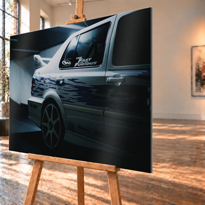 Nahaufnahme der hinteren Seitenpartie eines hellen VW Jetta mit blau-violetter Flammengrafik, großem Rad und Heckflügel. Im dunklen Seitenfenster steht „The Fast and the Furious“; kühles Licht fällt auf Wand und Boden; Visualisierung als Alu gebürstet-Wandbild, schräg von der Seite auf einer Holzstaffelei.