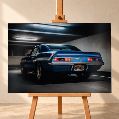 Blauer Chevrolet Camaro Yenko in tiefer Heck-Dreiviertelansicht in einer dunklen Parkgarage; rote Rücklichter, Heckspoiler, YENKO/SC-Seitenstreifen und kühle Deckenleuchten sind sichtbar; Visualisierung als Alu gebürstet-Wandbild, frontal auf einer Holzstaffelei.