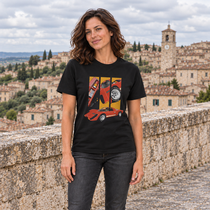 Frau von vorn im schwarzen T-Shirt mit Coyote-X-Sportwagenmotiv in Rot und Orange, an einer Steinmauer mit Altstadtkulisse.