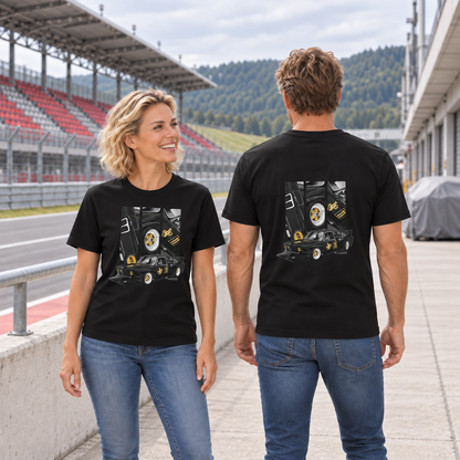 Frau von vorn und Mann von hinten in schwarzen T-Shirts mit BMW-E21-Motiven, an einer Betonbrüstung vor einer rot-grauen Rennstreckentribüne.
