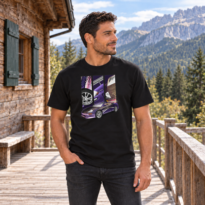Mann von vorn im schwarzen T-Shirt mit Mitsu-Lila-Motiv auf der Vorderseite, auf einer Holzterrasse vor einer Berghütte und Bergen.
