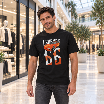 Mann von vorn im schwarzen T-Shirt mit Orange-Julius-Legends-Motiv auf der Vorderseite, im Atrium eines Einkaufszentrums mit Glasdach.