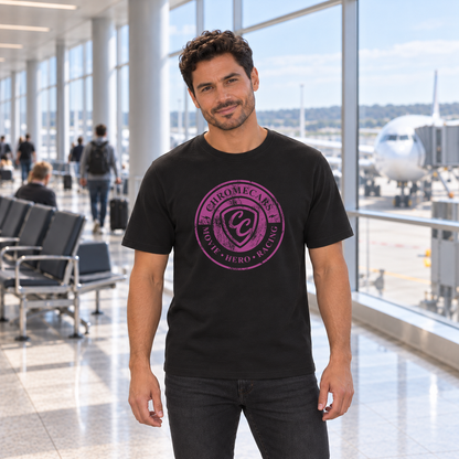Ein Mann steht mit gesenkten Armen im Flughafenterminal vor der Fensterfront. Er trägt ein schwarzes T-Shirt mit pinkem ChromeCars-Logo vorne; draußen steht ein Flugzeug.