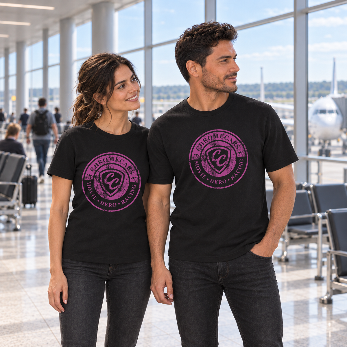 Zwei Personen stehen in schwarzen T-Shirts mit pinken ChromeCars-Logos vorne nebeneinander im Flughafenterminal. Beide blicken nach rechts; der Mann hat eine Hand in der Hosentasche.