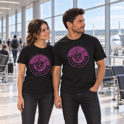 Zwei Personen stehen in schwarzen T-Shirts mit pinken ChromeCars-Logos vorne nebeneinander im Flughafenterminal. Beide blicken nach rechts; der Mann hat eine Hand in der Hosentasche.