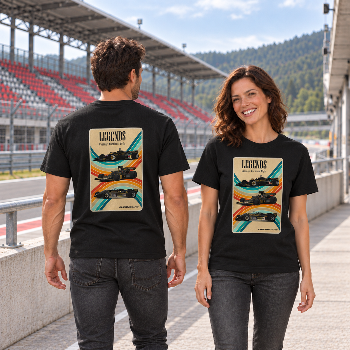 Frau von vorn und Mann von hinten in schwarzen T-Shirts mit Racing-Legends-Motiven, an einer Betonbrüstung vor einer rot-grauen Rennstreckentribüne.