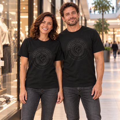 Zwei Personen stehen nebeneinander vor Schaufenstern im Shopping-Center und schauen nach vorn; beide tragen schwarze T-Shirts mit dezenten schwarzen Used-Logos auf der Vorderseite.