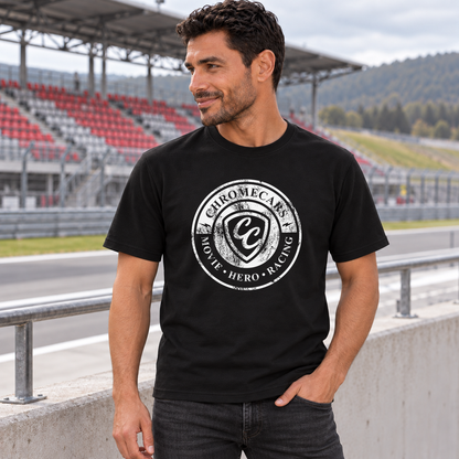Ein Mann im schwarzen T-Shirt mit weißem Used Logo vorne steht mit einer Hand in der Hosentasche und blickt zur Seite. Hinter der Betonbrüstung liegt die Rennstrecke mit rot-grauer Tribüne.