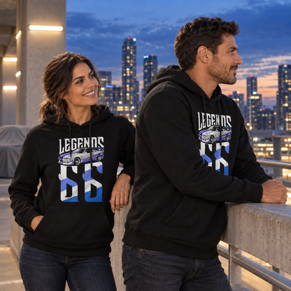 Mann und Frau in schwarzen Hoodies mit Brian’s Skyline als Legends-Frontmotiv stehen am Geländer des Parkdecks; der Mann blickt in die Stadt.