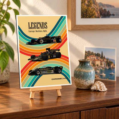 Mockup einer kleinen hochformatigen Alu-Dibond-Bildplatte auf einer Holzstaffelei, leicht schräg von vorn auf einer Holzkommode gezeigt. Das Motiv zeigt drei schwarz-goldene Formelrennwagen vor geschwungenen bunten Streifen auf beigefarbenem Grund und die Überschrift „LEGENDS“. Pflanze, Vase, Muschel und Küstenbilder sind Teil der Szenerie, nicht des Lieferumfangs.