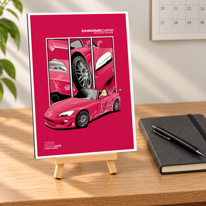 Mockup einer kleinen hochformatigen Alu-Dibond-Bildplatte auf Holzstaffelei in naher, leicht schräger Vorderansicht auf einem Holzschreibtisch. Auf magentafarbenem Grund mit weißem Rand sind Sukis pinker Honda S2000 in Front-Dreiviertelansicht und drei Fahrzeugdetails dargestellt. Notizbuch mit Stift, Wandkalender und Pflanze gehören zur Szenerie.