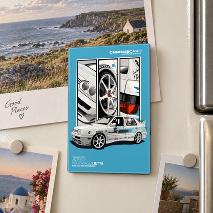 Illustrative Mockup-Nahaufnahme: Ein türkisfarbener, rechteckiger Motivmagnet am cremefarbenen Kühlschrank zeigt einen weißen Volkswagen Jetta mit blauen Dekorstreifen sowie Detailfelder von Scheinwerfern, Rad und Rücklicht. Rundherum hängen Reisefotos mit runden Magneten; rechts ist der Kühlschrankgriff sichtbar.