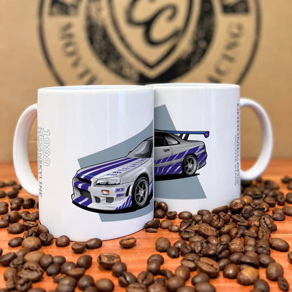 Zwei weiße Tassen mit silber-blauviolettem Nissan-Skyline-R34-Motiv zwischen Kaffeebohnen.