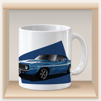Weiße Tasse mit blauem Yenko-Camaro-Motiv in einem Holzfach des Tassenregals.