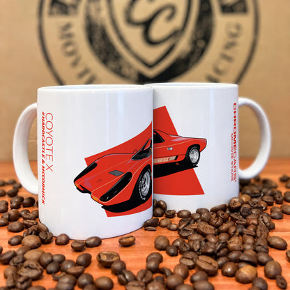 Zwei weiße Tassen mit rotem Coyote-X-Druck zwischen Kaffeebohnen.