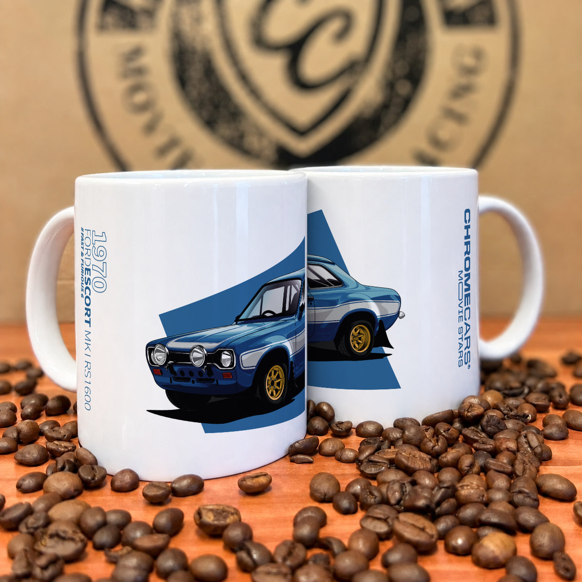 Zwei weiße Tassen mit Ford-Escort-Druck zwischen Kaffeebohnen.