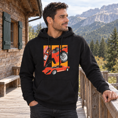 Mann im schwarzen Hoodie steht am Holzgeländer einer Berghüttenterrasse und blickt in die Ferne. Vorn ist ein rotes Fahrzeug unter drei orangefarbenen Detailfeldern sichtbar.