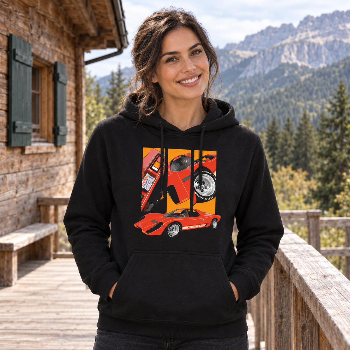 Frau im schwarzen Hoodie steht lächelnd vor einer Holzhütte. Ihre Vorderseite zeigt ein rotes flaches Fahrzeug und drei gerahmte orangefarbene Ausschnitte.