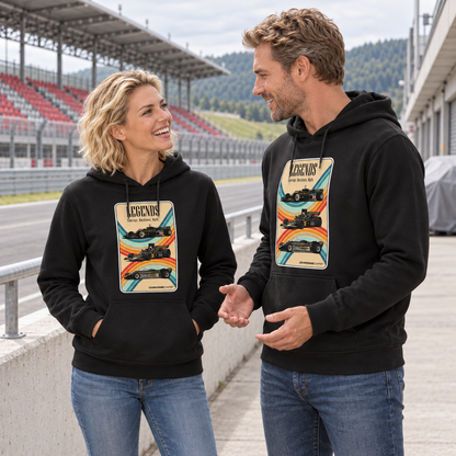 Paar in schwarzen Hoodies steht an einer Rennstreckentribüne. Beide Fronten zeigen die LEGENDS-Grafik mit drei Rennwagen und farbigen Bändern.