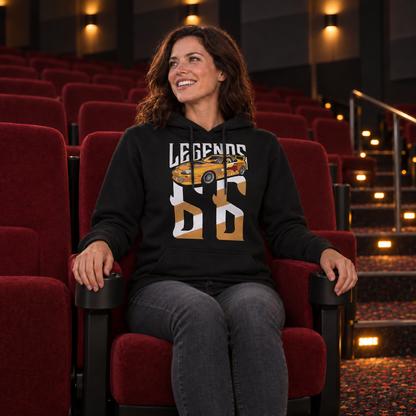 Frau im schwarzen Legends-Hoodie mit Slap Jack’s Supra auf der Vorderseite sitzt in einer roten Kino-Sitzreihe.