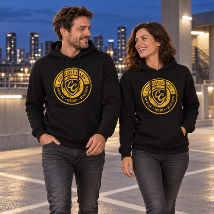 Zwei Personen gehen nebeneinander über ein Parkdeck und sehen einander an. Beide tragen schwarze Hoodies mit gelbem Stempelmotiv auf der Brust; hinter ihnen stehen beleuchtete Hochhäuser.