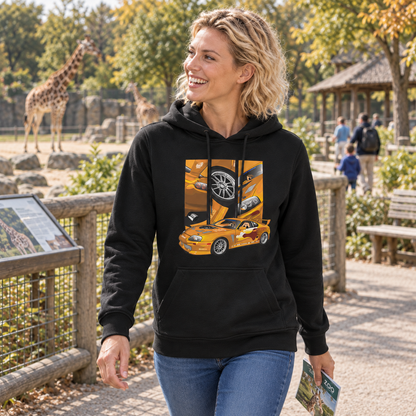 Frau im schwarzen Hoodie vor einem Zoogehege mit Giraffen. Ihre Vorderseite zeigt das orangefarbene Fahrzeugmotiv mit Heckflügel und drei gerahmten Feldern.